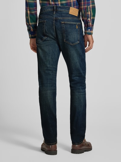 Männermodel trägt Straight Fit Jeans aus Baumwoll-Mix von POLO RALPH LAUREN, dunkelblauer Denim mit Whiskering, 5-Pocket, Ganzkörperansicht Rückansicht.