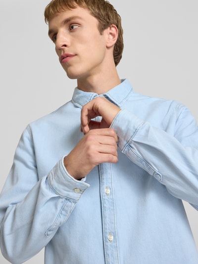 Männermodel trägt Regular Fit Jeanshemd mit Kentkragen von REVIEW in Hellblau, Reine Baumwolle, Knopfleiste, Nahaufnahme Oberkörper.