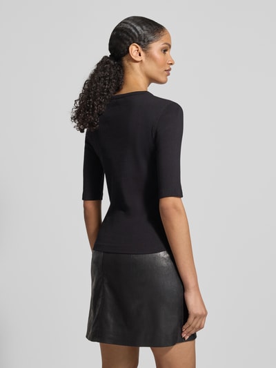Modelka kobieca ma na sobie Regular Fit Longsleeve mit Rundhalsausschnitt Modell 'Selay' od Drykorn, czarna bawełna, wzór strukturalny, krój regular fit, półrękaw, długość tyłu w rozmiarze S: 55 cm, widok sylwetki od tyłu.