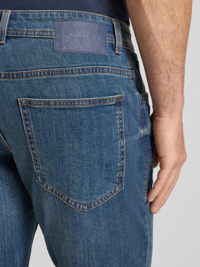 Männermodel trägt Regular Fit Jeans Bermudas aus Baumwoll-Mix von Tom Tailor in Denim-Optik mit Label-Patch, Detailaufnahme Rückansicht.