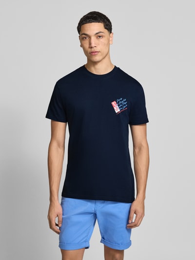 Männermodel trägt Regular Fit T-Shirt aus reiner Baumwolle von Tommy Jeans in Optik: Unifarben, Label-Print, Jersey, Rundhals, Kurzarm, Ganzkörperansicht von vorne.