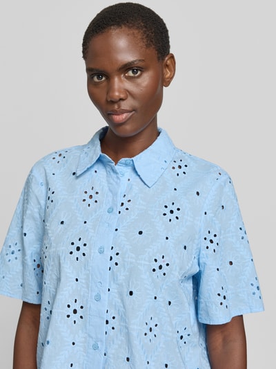 Kobieta nosi bluzkę koszulową Relaxed Fit Hemdbluse aus reiner Baumwolle Modell 'ELIZA' od Vero Moda, efekt: jednolity kolor, haft angielski, kołnierzyk koszulowy, dekolt w serek, listwa guzikowa, rękaw o dł. 1/2, bawełna, zbliżenie na górną część ciała