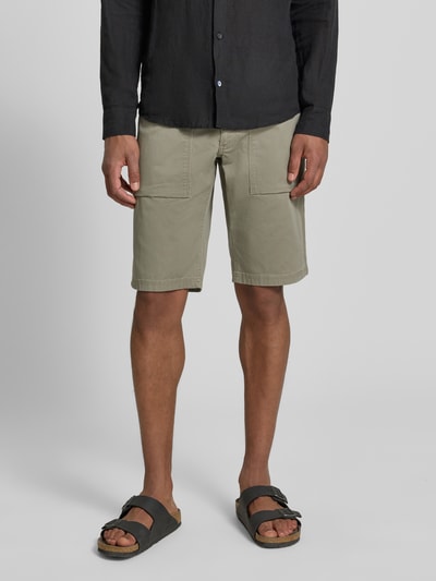 Mężczyznamodel nosi Regular Fit Cargoshorts aus Baumwoll-Mix od s.Oliver BLACK LABEL, efekt: jednolity kolor, krój regular fit, naszywka z logo, szlufki na pasek, zapięcie na guzik i ukryty zamek błyskawiczny, 5 kieszeni, splot twill, mieszanka bawełny; całkowity widok z przodu.