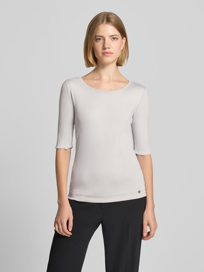 Frauenmodel trägt T-Shirt mit Rundhalsausschnitt und Label-Detail von Marc Cain im Slim Fit aus Baumwoll-Elasthan-Mix, Ganzkörperansicht von vorne.
