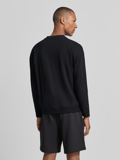 Männermodel trägt Regular Fit Sweatshirt aus Baumwoll-Mix Modell 'NOAH' von HUGO in Schwarz, Ganzkörperansicht Rückansicht, Herren T-Shirt von HUGO.