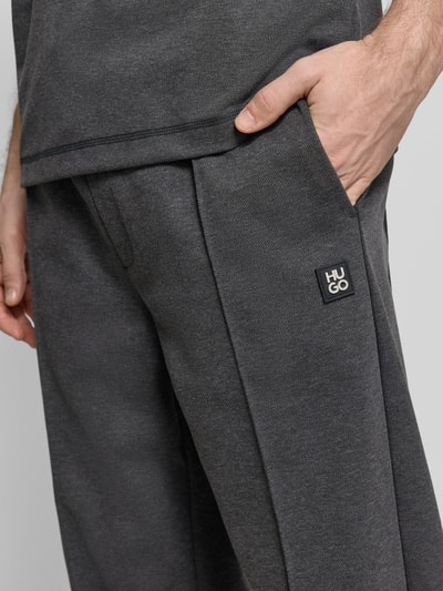 Męski model nosi Regular Fit Sweatpants aus Baumwoll-Mix Model 'DINETO' od HUGO, efekt: jednolity kolor, naszywka z logo, kanty, elastyczny ściągacz z tunelem, wpuszczane kieszenie boczne, kieszeń z tyłu, wykończenie: dzianina dresowa, mieszanka bawełny, detalaufnahme obszar bioder