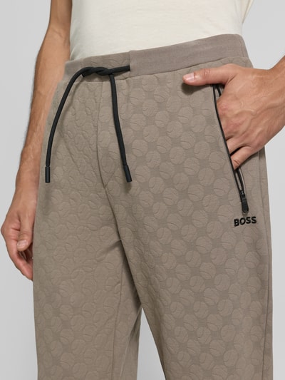 Männermodel trägt Regular Fit Sweathose aus Baumwoll-Mix Modell 'JT_Revival Hover' von BOSS, beige, strukturierte Oberfläche, Nahaufnahme Oberkörper, Herren Sweathose von BOSS GREEN