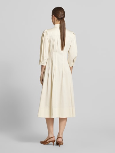 Frauenmodel trägt Cocktailkleid mit verdeckter Knopfleiste und 3/4-Arm von Christian Berg Cocktail aus Satin, Taillierter Schnitt, Midikleid, Hemdblusenkragen, Rückenlänge bei Größe 36: 116 cm, Brustweite bei Größe 36: 40 cm, Ärmellänge bei Größe 36: 46 cm, Farbton Creme, weich fallender Stoff, Ganzkörperansicht Rückansicht.