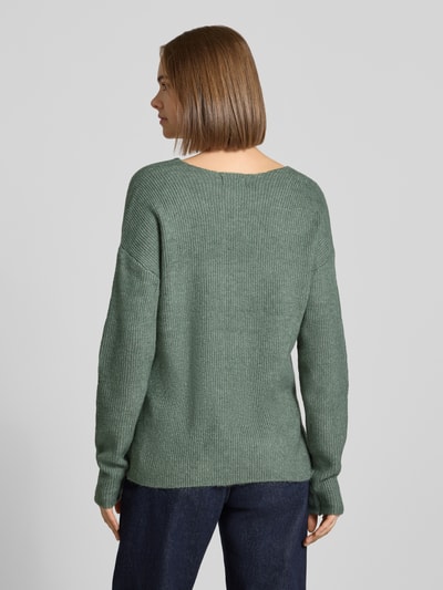 Frauenmodel trägt Regular Fit Pullover mit V-Ausschnitt Modell 'CAMILLA' von ONLY in Grün, Damen Pullover von ONLY, Ganzkörperansicht Rückansicht.