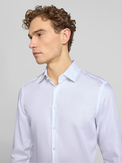 Männermodel trägt Slim Fit Business-Hemd mit Kentkragen von Jake*s in Weiß, reine Baumwolle, Knopfleiste, Nahaufnahme Oberkörper.