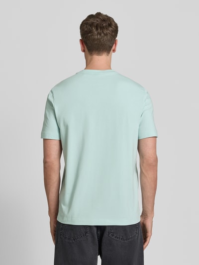 Männermodel trägt Relaxed Fit T-Shirt aus Baumwoll-Mix Modell 'TCHUP' von BOSS Orange in Hellgrün, unifarben, Ganzkörperansicht Rückansicht.