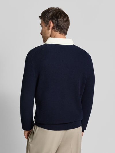 Männermodel trägt dunkelblauen Regular Fit Pullover aus Baumwoll-Woll-Mix von GANT, glatte Textur, Ganzkörperansicht Rückansicht.