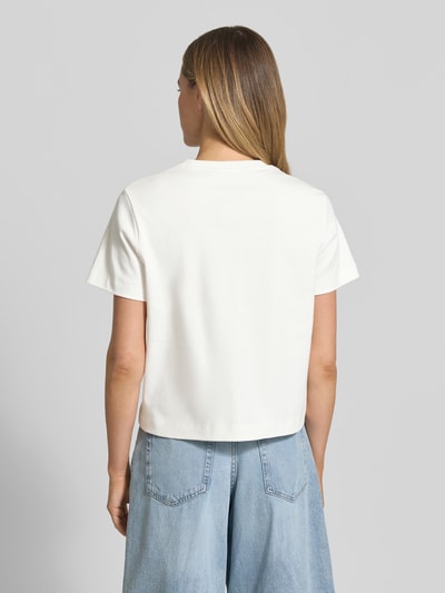 Frauenmodel trägt Regular Fit T-Shirt aus reiner Baumwolle Modell 'SARA' von Vero Moda, unifarben in Weiß, Ganzkörperansicht Rückansicht.