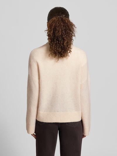 Frauenmodel trägt Regular Fit Strickjacke aus Woll-Mix Modell 'SIA' von Selected Femme, helle Farbe, strukturierte Oberfläche, Damen Strickjacke, Ganzkörperansicht Rückansicht.