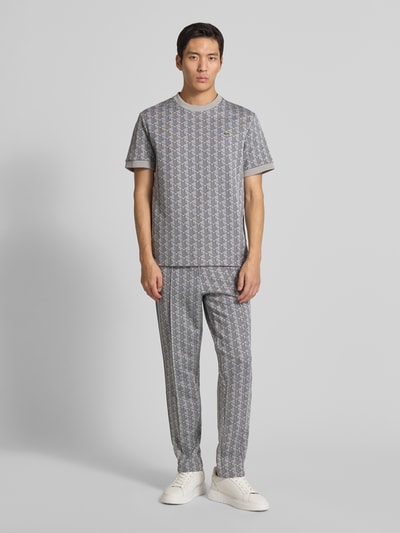 Männermodel trägt Regular Fit T-Shirt mit Baumwoll-Anteil von Lacoste, Optik: Unifarben, Muster: L-Monogramm, Logo-Patch, Rundhals, Kurzarm, Ärmelabschluss: gerippt, Ganzkörperansicht von vorne.