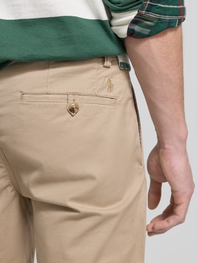 Mężczyznamodel nosi Spodnie materiałowe z kieszenią z tyłu od Polo Ralph Lauren, mieszanka bawełny i elastanu, krój slim fit, detal guzika, wpuszczane kieszenie, zapięcie na guzik i zamek błyskawiczny, szerokość w rozmiarze 32/32: 43 cm, długość wewnętrzna nogawki: 80 cm, zbliżenie na tył