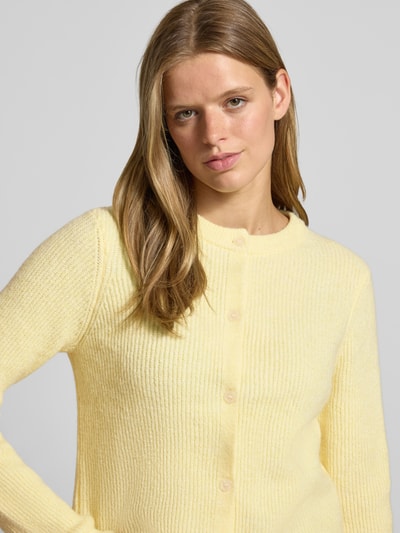 Frauenmodel trägt hellgelbe Strickjacke mit Woll-Anteil Modell 'SILLY' von PIECES, gerippte Struktur, Nahaufnahme Oberkörper.
