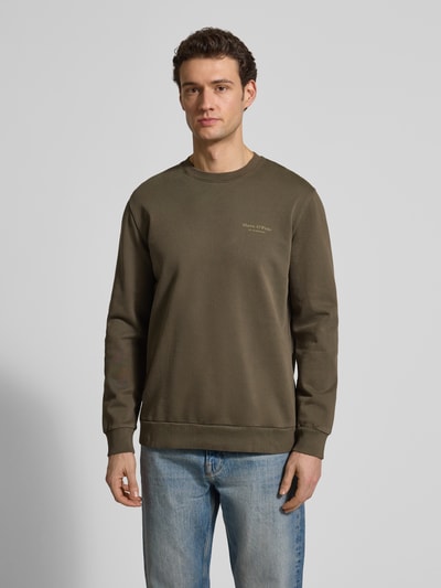 Männermodel trägt Regular Fit Sweatjacke aus reiner Baumwolle von Marc O'Polo in Olivgrün, unifarben, Crew Neck, Ganzkörperansicht von vorne.