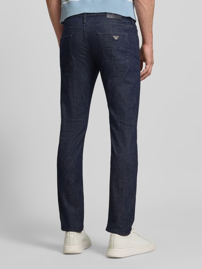 Männermodel trägt dunkelblaue Jeans mit Eingrifftaschen von Emporio Armani aus Baumwoll-Mix mit Stretch-Anteil, Slim-Fit, Ganzkörperansicht Rückansicht. Bundweite bei Größe 32/32: 43 cm, Innenbeinlänge: 79 cm.