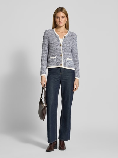 Modelka nosi Strickjacke mit Rundhalsausschnitt und Knopfleiste von Christian Berg Woman Selection, czarno-biała bawełna, krój regular fit, długość tyłu 54 cm, długość rękawa 66 cm, widok całej sylwetki z przodu.