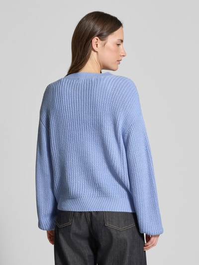 Vrouwenmodel draagt Regular Fit Strickjacke met eenrijige knoopsluiting model 'LEA' van Vero Moda in uni lichtblauw breisel, geribde boord, crew neck, lange mouw, materiaal: gebreid, geheel achteraanzicht.