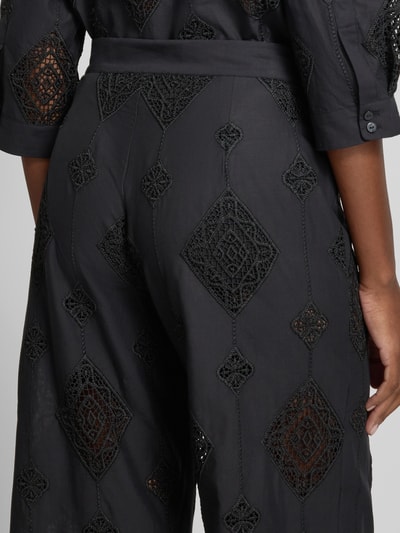 Frauenmodel trägt Hose aus Baumwolle mit Häkelspitze Modell 'MIKE' von Bash, schwarze Flared-Cut Damen Hose, Detailaufnahme Rückansicht.