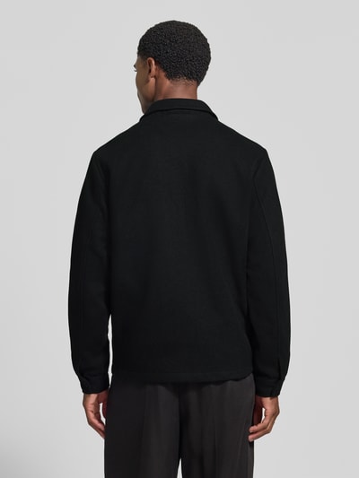 Männermodel trägt Jacke mit Brusttasche und Kentkragen Modell 'ROLFSTED' von Casual Friday in Schwarz, gerade Form, Ganzkörperansicht Rückansicht.
