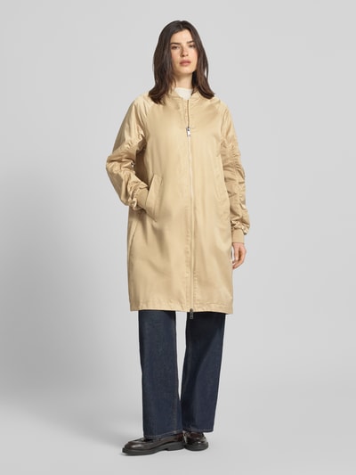 Vrouwenmodel draagt Regular Fit jack met opstaande kraag model 'Ali' van Beaumont Amsterdam in beige met plooien, tweewegritssluiting, elastische mouwboord, steekzakken, ruglengte maat 36: 97 cm, schouderbreedte: 47 cm, borstwijdte: 55 cm, mouwlengte: 60 cm, volledig frontaal totaalbeeld.