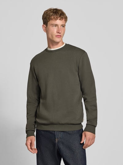 Männermodel trägt Regular Fit Sweatshirt aus Baumwoll-Mix Modell 'CERES' von ONLY & SONS in Olivgrün, Ganzkörperansicht von vorne.