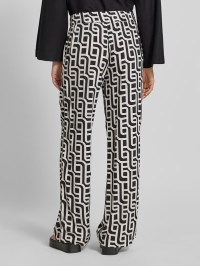 Vrouwenmodel draagt Wide Leg Pants uit viscose met steekzakken van Christian Berg Woman, zwart-wit geometrisch patroon, los model, elastische band, detailopname rugaanzicht
