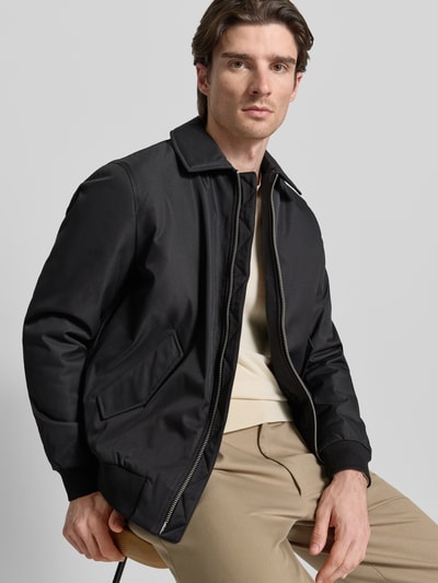 Männermodel trägt Jacke mit Reißverschluss von MCNEAL in Schwarz, Kentkragen, Pattentaschen, Regular-Fit, gerippte Abschlüsse, Nahaufnahme Oberkörper. Rückenlänge bei Größe M: 68 cm, Schulterbreite: 48 cm, Brustweite: 57 cm, Ärmellänge: 65 cm.