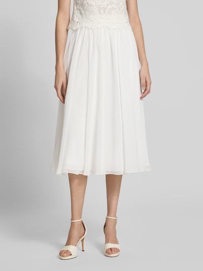 Modelka nosi Midirock aus Chiffon mit Reißverschluss od Luxuar, biała, A-linia, zwiewna tkanina, Szerokość w rozmiarze 36: 38 cm, długość całkowita 77 cm. Zbliżenie na dolną część ciała.
