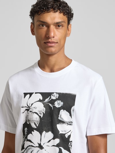 Männermodel trägt weißes Herren T-Shirt mit Motiv-Print Modell 'LUCAS' von Jack & Jones Premium aus reiner Baumwolle und Rundhalsausschnitt, Slim-Fit, Nahaufnahme Oberkörper.