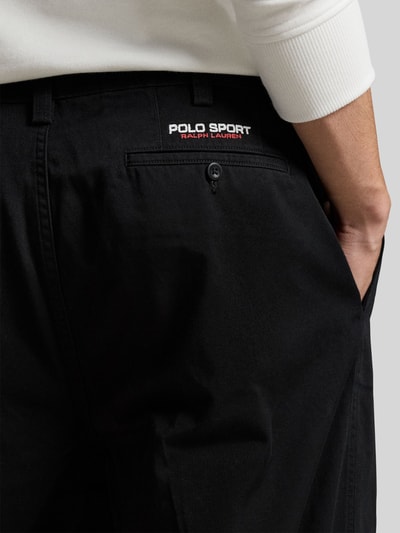 Mężczyznamodel nosi Regular Fit Weite Hose aus reiner Baumwolle von Polo Ralph Lauren, czarny, gładki materiał, tylna kieszeń, detal haftowanego logo, materiał bawełniany, detaliczne ujęcie tyłu.