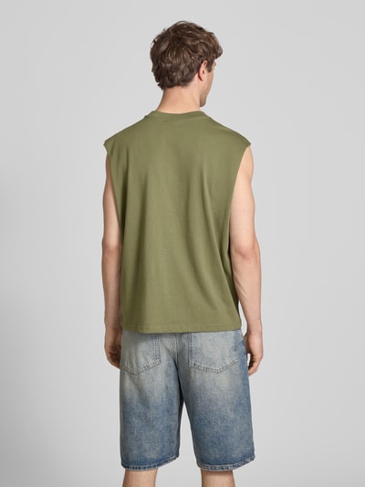 Männermodel trägt Muskelshirt mit Logo und Rundhalsausschnitt von REVIEW in Olive, kombiniert mit Jeansshorts, Ganzkörperansicht Rückansicht.