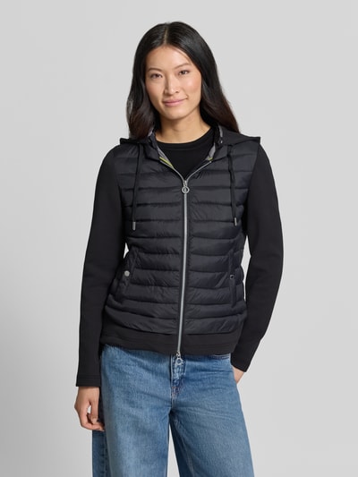 Kobieta modelka nosi Jacke aus Baumwoll-Mix in Stepp-Optik od FUCHS SCHMITT, czarna mieszanka bawełny, krój taliowany, kaptur z tunelem, zamek błyskawiczny dwustronny, Długość tyłu w rozmiarze 36: 59 cm, Szerokość ramion w rozmiarze 36: 40 cm, Szerokość klatki piersiowej w rozmiarze 36: 48 cm, Długość rękawów w rozmiarze 36: 67 cm, z efektem pikowania, gładka tekstura, widok całej sylwetki z przodu.