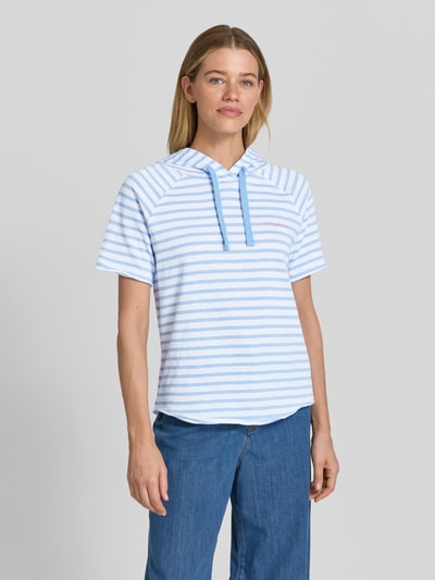 Modelka prezentuje Relaxed Fit Sweatshirt mit Kapuze und 1/2-Arm von Smith and Soul, bawełna, krój relaxed fit, kaptur z tunelem, wzór na całej powierzchni, haft, rękaw o dł. 1/2, widok całej sylwetki z przodu.