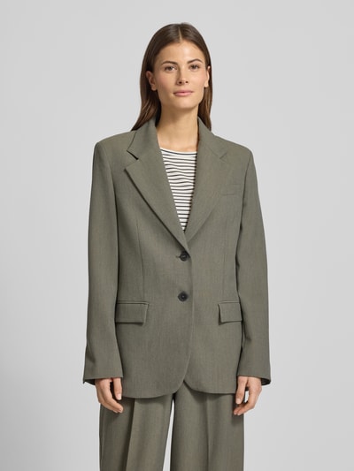 Frauenmodel trägt Relaxed Fit Blazer mit Viskose-Anteil Modell 'Napoli' von Mango in Oliv, Doppelknopfleiste, Reverskragen, Ganzkörperansicht von vorne.
