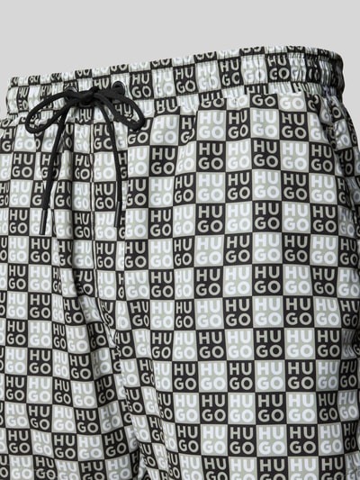 Produktfoto, Regular Fit Badeshorts mit Label-Prägung Modell 'AARON' von HUGO, Optik: Unifarben, Passform: Regular-Fit, Applikation: Label-Print, Bundabschluss: elastisch mit Tunnelzug, Taschen: seitliche Eingrifftaschen; geometrisches Muster in Schwarz, Weiß und Grau, glatte Textur