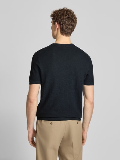 Männermodel trägt T-Shirt aus Baumwoll-Leinen-Mix von Profuomo in Schwarz, kombiniert mit beigefarbener Hose, Ganzkörperansicht Rückansicht. Slim Fit, Rundhalsausschnitt, Rückenlänge bei Größe M 70 cm.