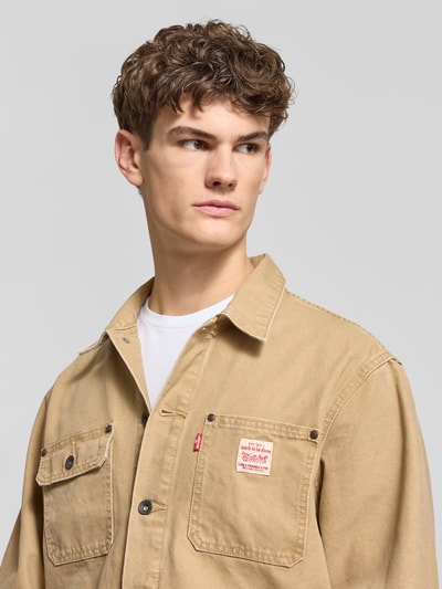 Männermodel trägt Jacke mit Knopfleiste von Levi's®, Reine Baumwolle, Regular-Fit, Kentkragen, Label-Detail, Nahaufnahme Oberkörper.