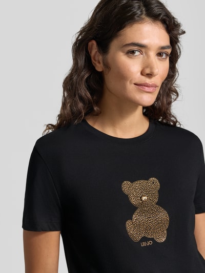 Kobiece model prezentuje Slim Fit T-Shirt mit Ziersteinbesatz von Liu Jo White z bawełny z Motyw, okrągły dekolt, długość tyłu w rozmiarze S: 57 cm, zbliżenie na górną część ciała