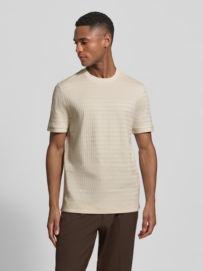 Männermodel trägt Regular Fit T-Shirt aus reiner Baumwolle Modell 'THOMSON' von BOSS in Beige, feines Strukturmuster, Ganzkörperansicht von vorne.