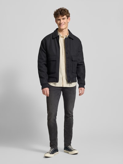 Männermodel trägt Stone Washed Slim Fit Jeans von ONLY & SONS in dunklem Grau, Baumwollmischung mit Stretch-Anteil, Ganzkörperansicht von vorne.