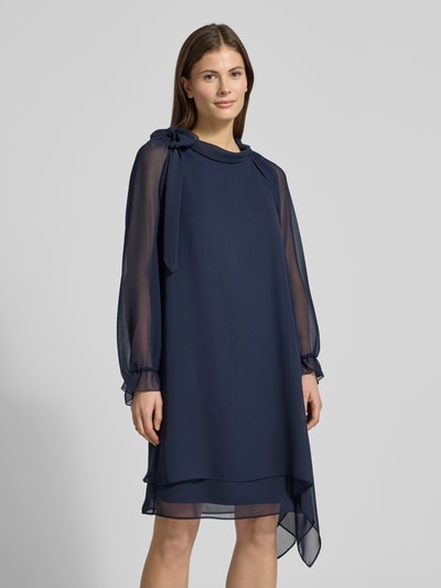 Frauenmodel trägt Relaxed Fit Bolero in semitransparentem Design von V.M., dunkelblau, Rüschenbesatz, Rückenlänge 41 cm, Langärmelig, Ganzkörperansicht von vorne.