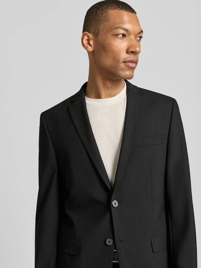 Männermodel trägt Anzug mit Reverskragen und Bügelfalte von HECHTER PARIS in Schwarz, Material-Mix mit Schurwolle-Anteil, Nahaufnahme Oberkörper.