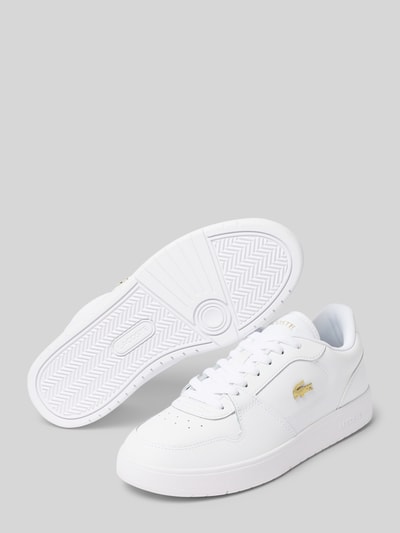 Produktfoto, Sneaker mit Logo-Patch von Lacoste in Weiß mit goldenen Details, glatte Oberfläche, klare Linien, Damen Sneaker von Lacoste