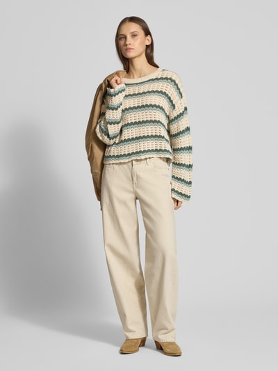 Frauenmodel trägt Regular Fit Strickpullover aus Baumwoll-Mix Modell 'ASA' von ONLY in mehrfarbiger Optik mit gestreiftem Lochstrickmuster, Cropped-Länge, Crew Neck, überschnittenen Schultern, Langarm mit Muschelsaum, Materialverarbeitung: Baumwoll-Mix, Ganzkörperansicht von vorne.