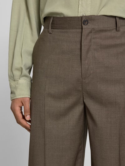 Männermodel trägt Wide Fit Stoffhose aus Woll-Mix von Filippa K, braun, elastischer Woll-Mix, Bügelfalten, Nahaufnahme Oberkörper.