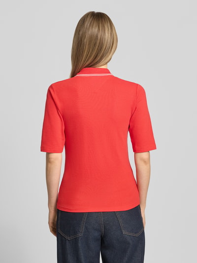 Frauenmodel trägt Slim Fit Poloshirt aus Lyocell-Mix von Tommy Hilfiger, Optik: Unifarben, Kontraststreifen, 1/2-Arm, Piqué, Ganzkörperansicht Rückansicht